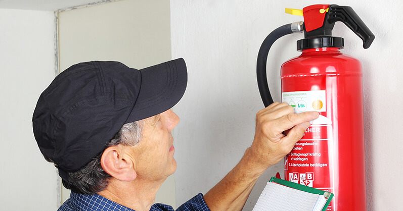 Man Checking Fire Extinguisher regulations
