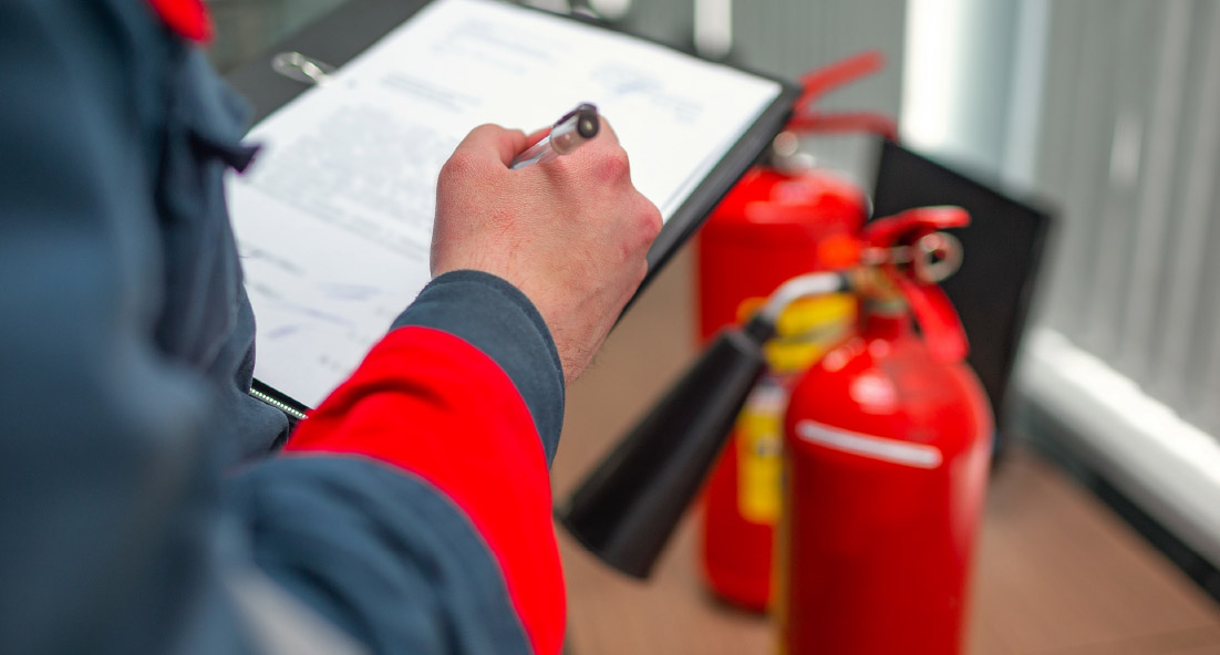 An engineer conducting fire safety maintenance checks with his clipboard