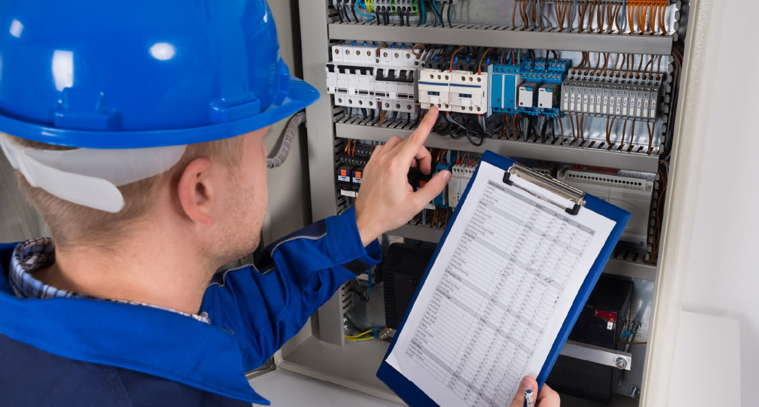 An engineer conducting fire safety electrical checks on a circuit board